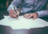 Group risk payouts hit record £2.69bn as return-to-work support grows A man writing on paper.