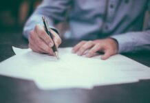 Group risk payouts hit record £2.69bn as return-to-work support grows A man writing on paper.