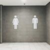 Men's and women's signs outside a toilet.