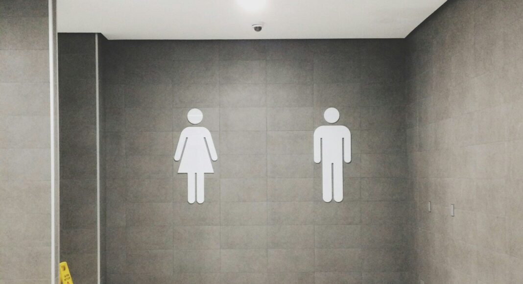 Men's and women's signs outside a toilet.