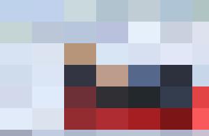 A group of six HR personnel in life jackets rowing a red boat on a lake.