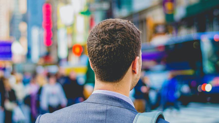 A man in a suit, seen from behind, stands in a busy urban setting with people walking and blurred vehicles in the background, embodying the essence of human resources personnel as he navigates through the complexities of people management. A man in a suit, seen from behind, stands in a busy urban setting with people walking and blurred vehicles in the background, embodying the essence of human resources personnel as he navigates through the complexities of people management.