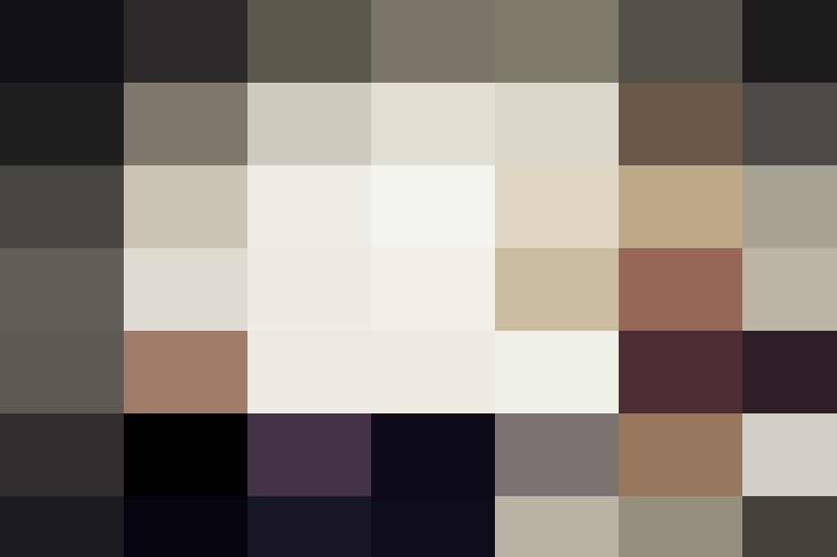 A woman, typing on a typewriter, is wearing glasses.