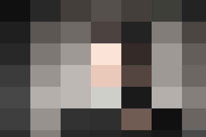 A man in a black shirt is looking directly at the camera.