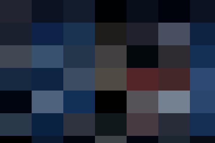 A man in a ski jacket and goggles is posing in the snow.