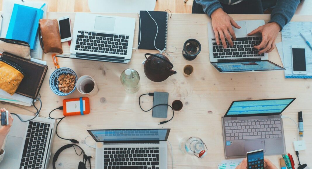 People working on laptops around a table.