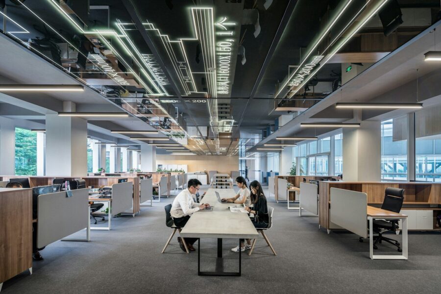 People at desks in an open-plan office.