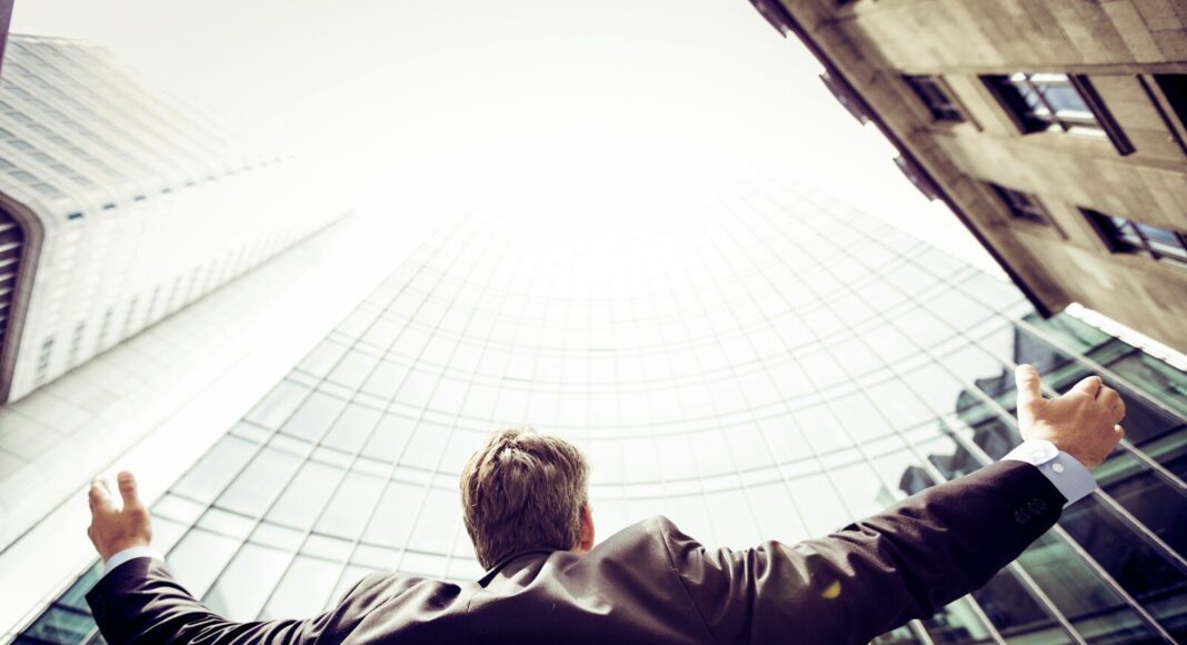 low-angle photography of man in the middle of buildings.