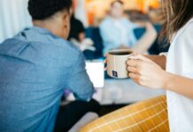 Revealed: Workers ‘spend £48bn a year’ just to stay awake at work A woman holds a mug of coffee at an office.