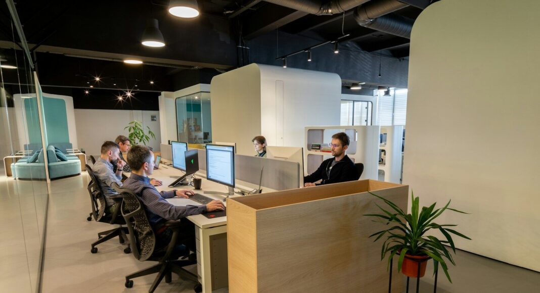 A group of people sitting at desks in an office.