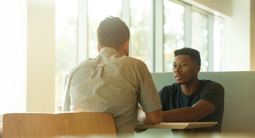 Two men talking at a table.