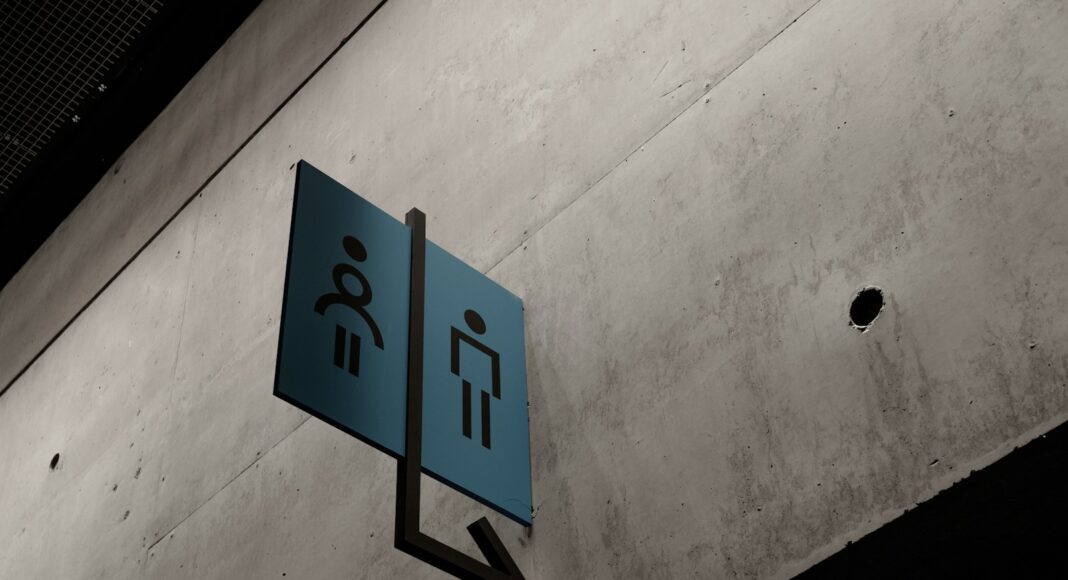 A sign pointing to male and female toilets.
