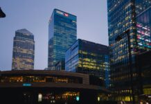 HSBC weighs 20,000 job cuts as AI push puts thousands of roles at risk Skyscrapers pictured in the evening, one with the HSBC logo at the top.
