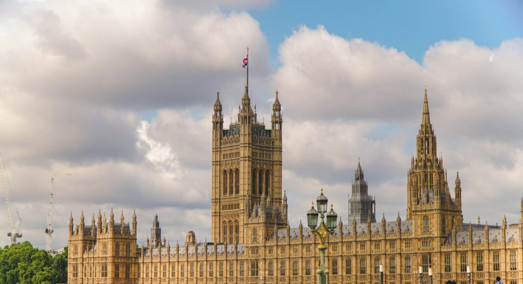 The houses of parliament stand under a cloudy sky.