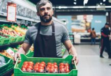 Food workforce crisis deepens as labour shortages threaten supply and service A grocery store worker holds a box of tomatoes.
