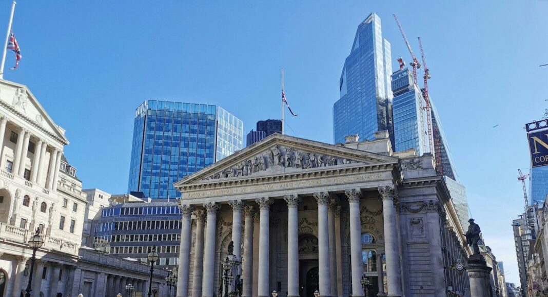 The Bank of England building in the foreground with London skyscrapers in the background.